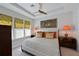Inviting bedroom featuring neutral colors, a tray ceiling, and bright windows with leafy patterned shades at 6308 Plateau Ct, Bradenton, FL 34203