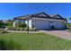 Charming single-story home boasts a tile roof, manicured lawn, and a two-car garage at 6308 Plateau Ct, Bradenton, FL 34203