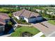 Stunning aerial view of a single-story home featuring a tile roof, three-car garage, and beautiful landscaping at 6308 Plateau Ct, Bradenton, FL 34203