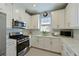 Bright kitchen with stainless steel appliances, white cabinets, and a clean, modern design at 6308 Plateau Ct, Bradenton, FL 34203