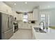 Well-lit kitchen features white cabinets, stainless steel appliances, and a functional layout at 6308 Plateau Ct, Bradenton, FL 34203