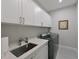 Modern laundry room featuring white cabinets, quartz countertops, and updated washer and dryer at 6308 Plateau Ct, Bradenton, FL 34203