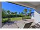 Inviting patio with brick pavers, lounge chairs, and a serene view of the lush backyard with palm trees at 6308 Plateau Ct, Bradenton, FL 34203