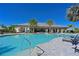 Stunning community pool with lounge chairs and palm trees under a clear blue sky at 6308 Plateau Ct, Bradenton, FL 34203
