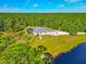 Aerial view of a house near a pond, with sprawling yard surrounded by a lush forest at 6407 213Th E St, Bradenton, FL 34211