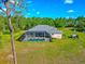 Aerial view of a home featuring a screened pool and spacious yard, set amidst lush greenery at 6407 213Th E St, Bradenton, FL 34211