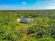 Aerial view showing a serene pond and well-maintained home nestled among lush, mature trees at 6407 213Th E St, Bradenton, FL 34211