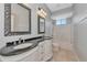Bathroom featuring dual sinks, decorative mirrors, and a tub/shower with a window at 6407 213Th E St, Bradenton, FL 34211