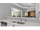 Kitchen area with white countertops and stainless steel sink leading to outdoor patio at 6407 213Th E St, Bradenton, FL 34211