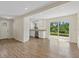 Bright, open-concept kitchen and living area boasts sleek wood floors, white cabinets and island, and natural light at 6718 68Th E Ave, Bradenton, FL 34203