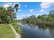 Scenic waterfront view of a tranquil river lined with lush greenery and palm trees on a sunny day at 6718 68Th E Ave, Bradenton, FL 34203