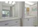 Well-lit bathroom with a large mirror, white cabinets, and a glimpse of the outdoor view at 7173 W Country Club N Dr # 141, Sarasota, FL 34243