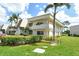 Well-maintained condo building with lush landscaping, mature palms, and bright sunny skies at 7173 W Country Club N Dr # 141, Sarasota, FL 34243