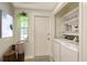 Laundry room with washer, dryer, shelves, decor, and door to outside at 7173 W Country Club N Dr # 141, Sarasota, FL 34243