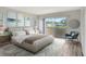 Bedroom with a neutral palette, large bed, accent chair, and access to the balcony with neighborhood views at 7173 W Country Club N Dr # 141, Sarasota, FL 34243