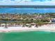 Aerial view showcases beach homes with ocean frontage and clear, turquoise waters at 8592 Hidden Lagoon Rd, Sarasota, FL 34242