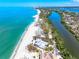 Breathtaking aerial view of the coast with beach homes next to clear, turquoise waters at 8592 Hidden Lagoon Rd, Sarasota, FL 34242