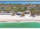 Aerial view showcases beach houses with ocean frontage and clear, turquoise waters at 8592 Hidden Lagoon Rd, Sarasota, FL 34242
