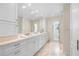 Bright bathroom featuring a long vanity with double sinks, ample storage, and a glass-enclosed shower at 8592 Hidden Lagoon Rd, Sarasota, FL 34242