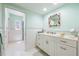 Bright bathroom showcasing vanity with shell mirror, white tiling, and turquoise accents at 8592 Hidden Lagoon Rd, Sarasota, FL 34242