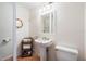 Bright bathroom with a pedestal sink, tiled floors, and a decorative mirror at 8592 Hidden Lagoon Rd, Sarasota, FL 34242