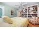 Bedroom featuring a large bookcase, light green walls, and a ceiling fan at 8592 Hidden Lagoon Rd, Sarasota, FL 34242