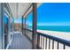 Covered porch with columns and railings and a clear view of the beach and ocean at 8592 Hidden Lagoon Rd, Sarasota, FL 34242