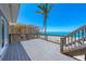 Large deck with railing overlooks the white sand beach and the blue ocean at 8592 Hidden Lagoon Rd, Sarasota, FL 34242