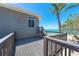 The light gray house has a gray deck with railings and stairs down to the beach at 8592 Hidden Lagoon Rd, Sarasota, FL 34242