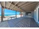 Large covered deck with a view of the white sand beach and blue water at 8592 Hidden Lagoon Rd, Sarasota, FL 34242