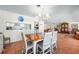 Dining area with a wooden table and seating for six under a chandelier and views into the living room at 8592 Hidden Lagoon Rd, Sarasota, FL 34242