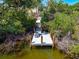 Wooden dock surrounded by lush greenery, providing access to a serene waterway at 8592 Hidden Lagoon Rd, Sarasota, FL 34242