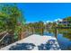 Scenic wooden dock with sturdy posts providing access to a tranquil, sun-drenched waterway at 8592 Hidden Lagoon Rd, Sarasota, FL 34242