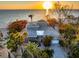 Striking aerial view of a beachfront property with mature trees, expansive roofline, and tranquil ocean vista at 8592 Hidden Lagoon Rd, Sarasota, FL 34242