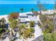 Lovely beach house surrounded by palm trees, set against the backdrop of white sands and turquoise ocean at 8592 Hidden Lagoon Rd, Sarasota, FL 34242
