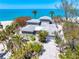 Majestic beach house surrounded by lush tropical foliage, with ocean views and pristine sands at 8592 Hidden Lagoon Rd, Sarasota, FL 34242