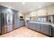 Spacious kitchen with stainless steel refrigerator, abundant cabinetry, granite counters, and terra cotta tile flooring at 8592 Hidden Lagoon Rd, Sarasota, FL 34242