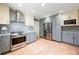 This kitchen features stainless steel appliances, two-tone cabinets, granite counters, and terra cotta tile flooring at 8592 Hidden Lagoon Rd, Sarasota, FL 34242