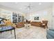 Spacious living room featuring a built-in bookcase, whitewashed floors, and neutral-toned furniture at 8592 Hidden Lagoon Rd, Sarasota, FL 34242