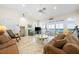 Spacious living room with an ocean view, plantation shutters, comfortable furniture, and a ceiling fan at 8592 Hidden Lagoon Rd, Sarasota, FL 34242