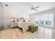 Serene main bedroom with whitewashed floors, a decorative chest, and balcony access with ocean view at 8592 Hidden Lagoon Rd, Sarasota, FL 34242