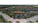 Aerial shot of community clubhouse, tennis courts, and pool area overlooking a serene lake at 8721 Trattoria Ter, Sarasota, FL 34238