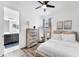Bright bedroom boasts hardwood floors, a rustic dresser, and an en-suite bathroom at 8721 Trattoria Ter, Sarasota, FL 34238