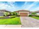 Beautiful home with a terracotta tiled roof, paver driveway, lush lawn and tropical landscaping at 8721 Trattoria Ter, Sarasota, FL 34238