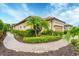 Charming home with a terracotta tiled roof, paver walkway, and tropical landscaping at 8721 Trattoria Ter, Sarasota, FL 34238