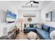 Cozy living room with blue sectional sofa, flat-screen TV, and tray ceiling, perfect for relaxation at 8721 Trattoria Ter, Sarasota, FL 34238