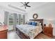 Primary bedroom featuring hardwood floors, a ceiling fan, and large windows offering ample natural light at 8721 Trattoria Ter, Sarasota, FL 34238