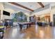 Spacious recreation room with a pool table, bar, kitchenette, and ample natural light at 8721 Trattoria Ter, Sarasota, FL 34238