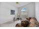 Bedroom area with a large window providing ample natural light, accompanied by a sofa and desk at 8824 Havenridge Dr, Sarasota, FL 34238