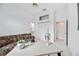 Bright bedroom features a sofa, closet, and view into the bathroom with neutral wall color at 8824 Havenridge Dr, Sarasota, FL 34238